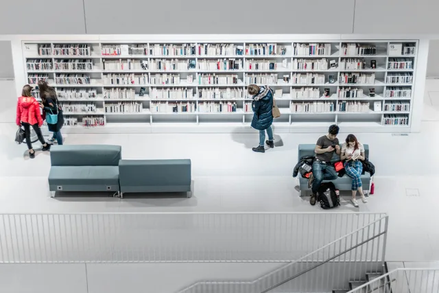 A library of books with people accessing resources